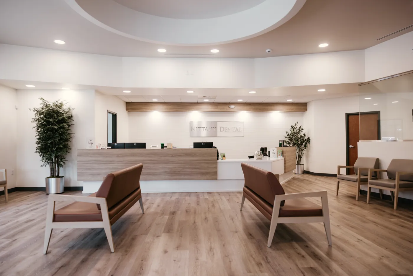 The reception at Nittany Dental Associates, with the brushed-steel Nittany Dental sign above the front desk